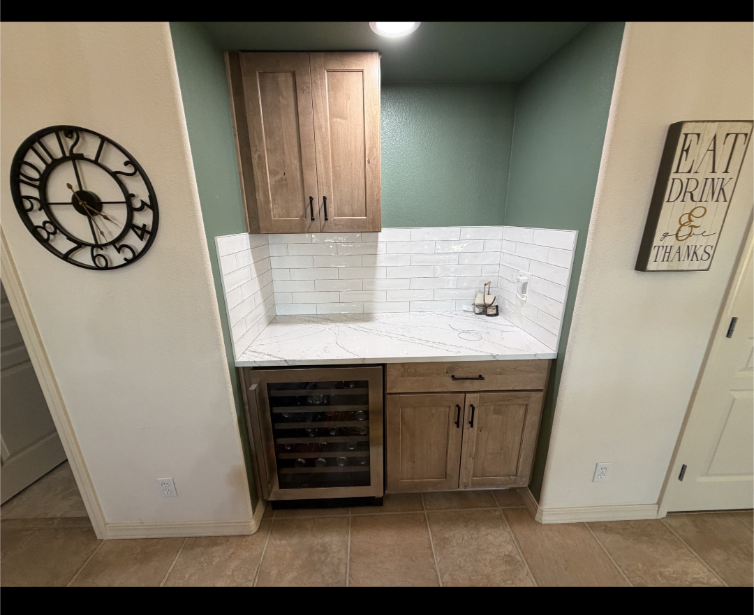 Remodeled beverage bar nook with stained wood shaker cabinetry, quartz counter, white subway tile backsplash and a built-in wine fridge