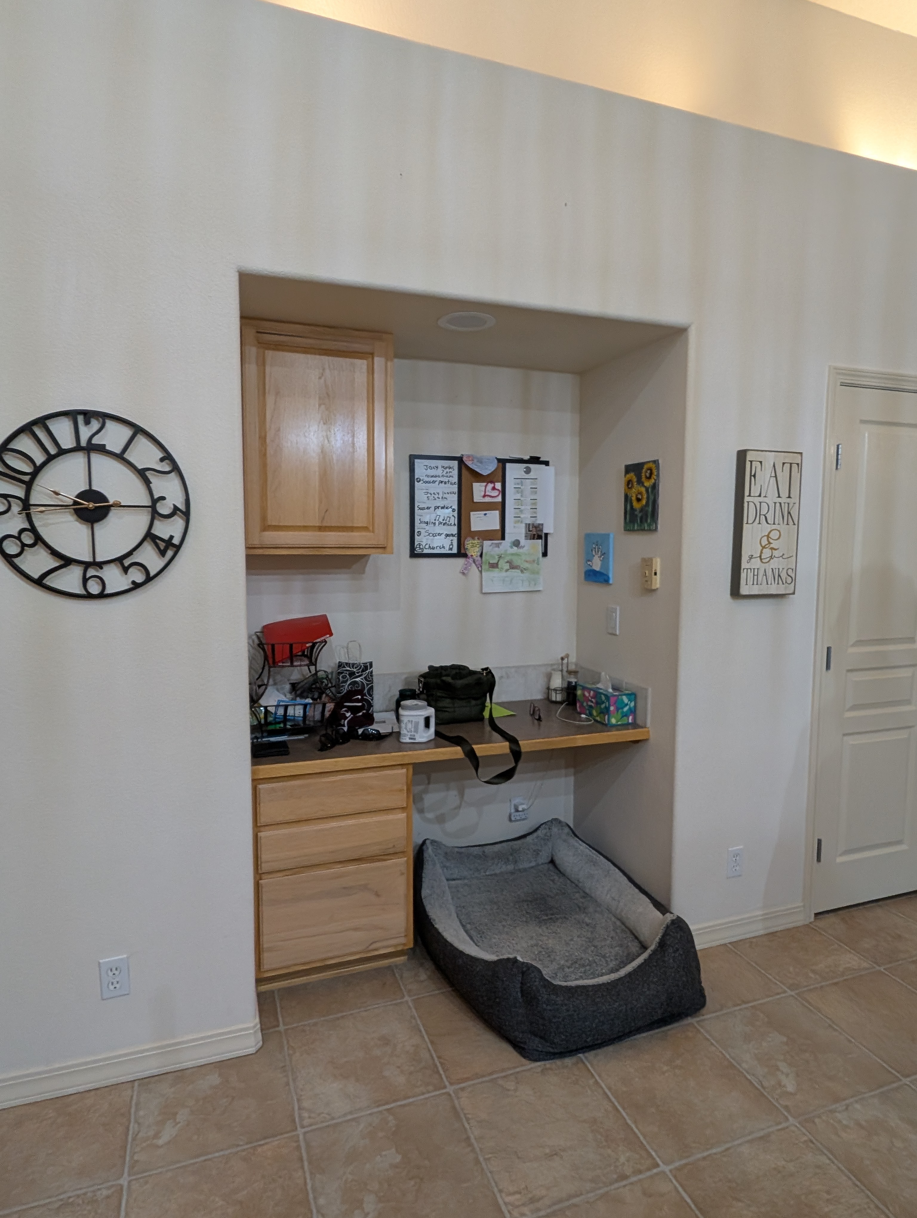 Cluttered built-in maple desk nook used as a home office before remodel