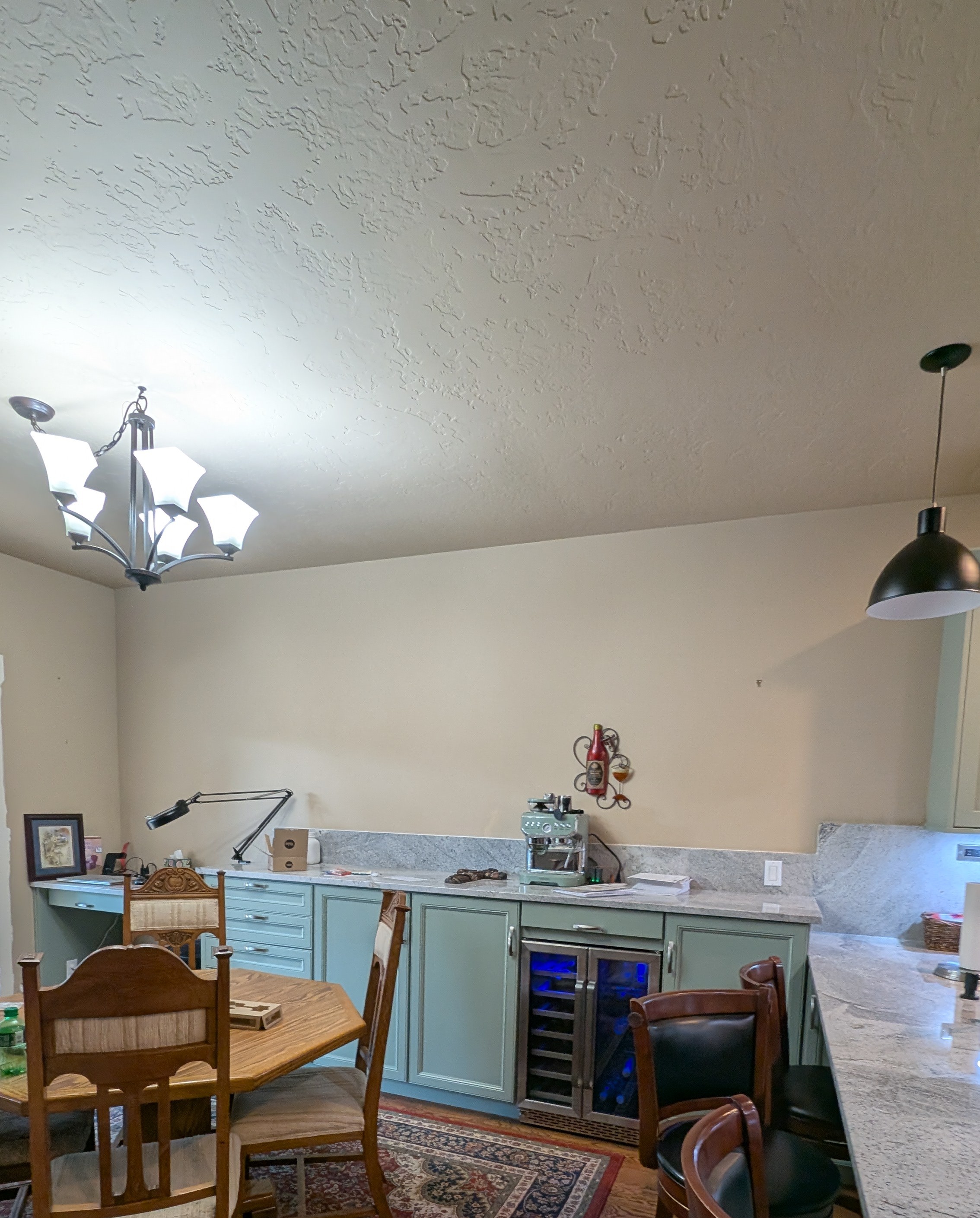 Remodeled sage green shaker kitchen with gray granite counters and stainless gas range