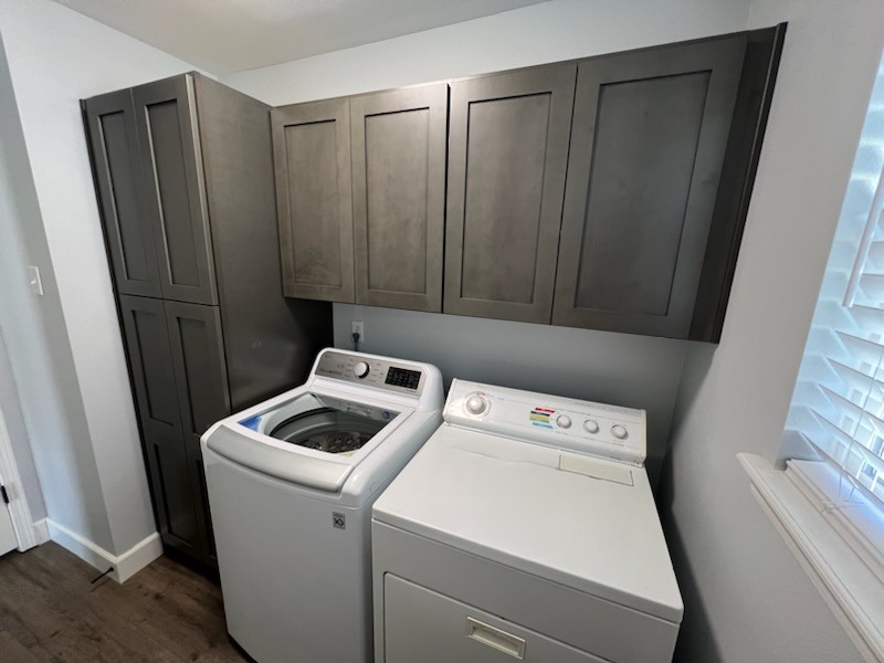 Laundry room with taupe-gray cabinets, a tall pantry cabinet and a white washer and dryer