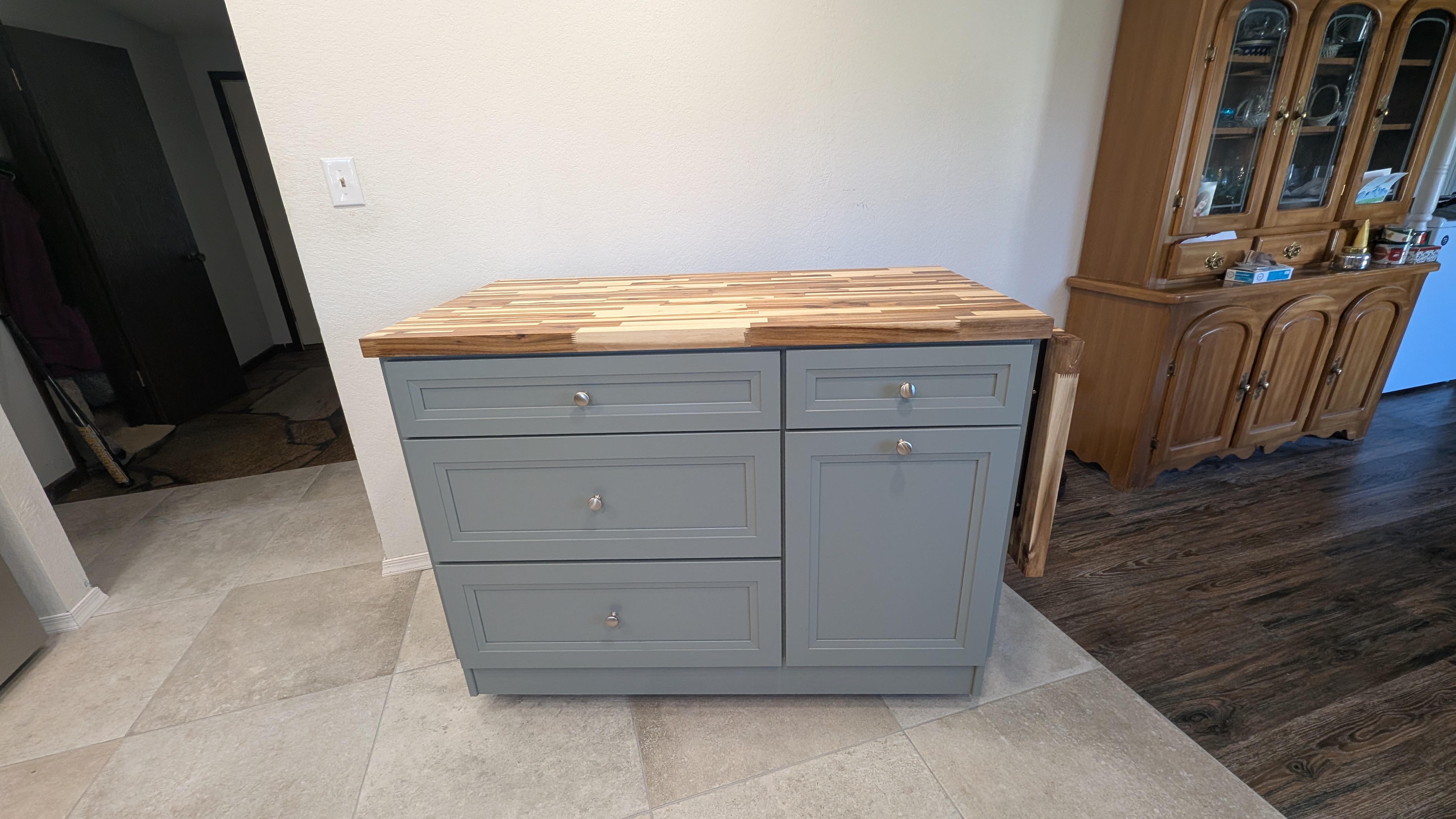 Gray kitchen island with a butcher-block wood top and a pull-out extension